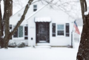 outside of a white home in the snow