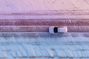 white car driving on a snow covered road