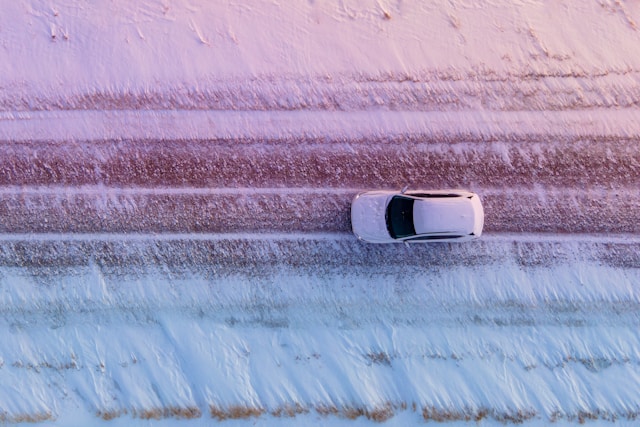 white car driving on a snow covered road